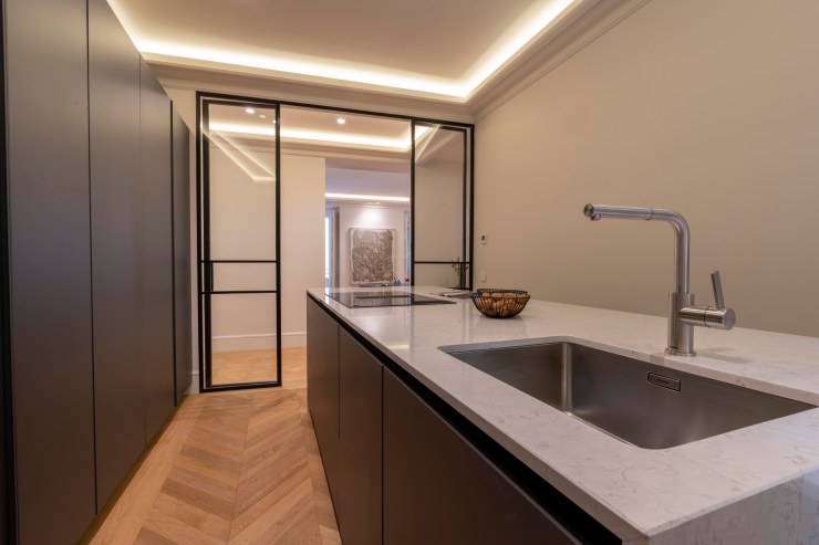 Cocina de diseño con barra y acabados de alta calidad en piso de Alcobendas Norte.