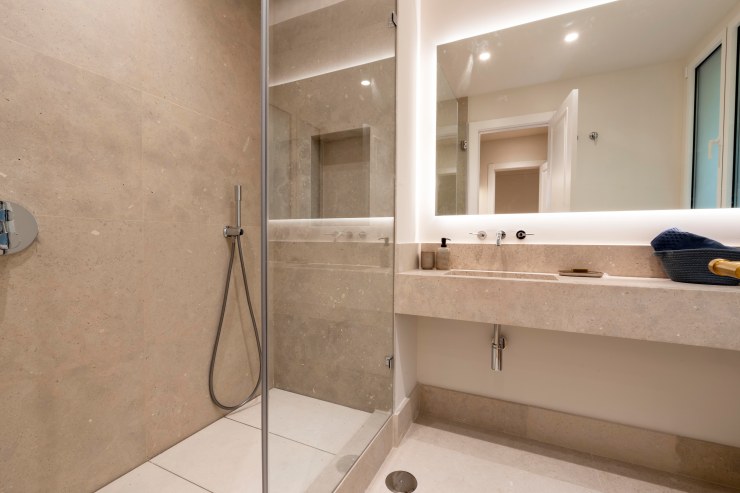 Fotografía de baño de cortesía con acabados de diseño en inmueble premium de Pozuelo.