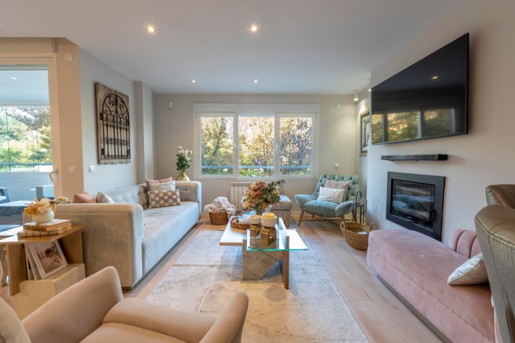 Salón principal amplio y luminoso con chimenea de diseño en chalet Aravaca.